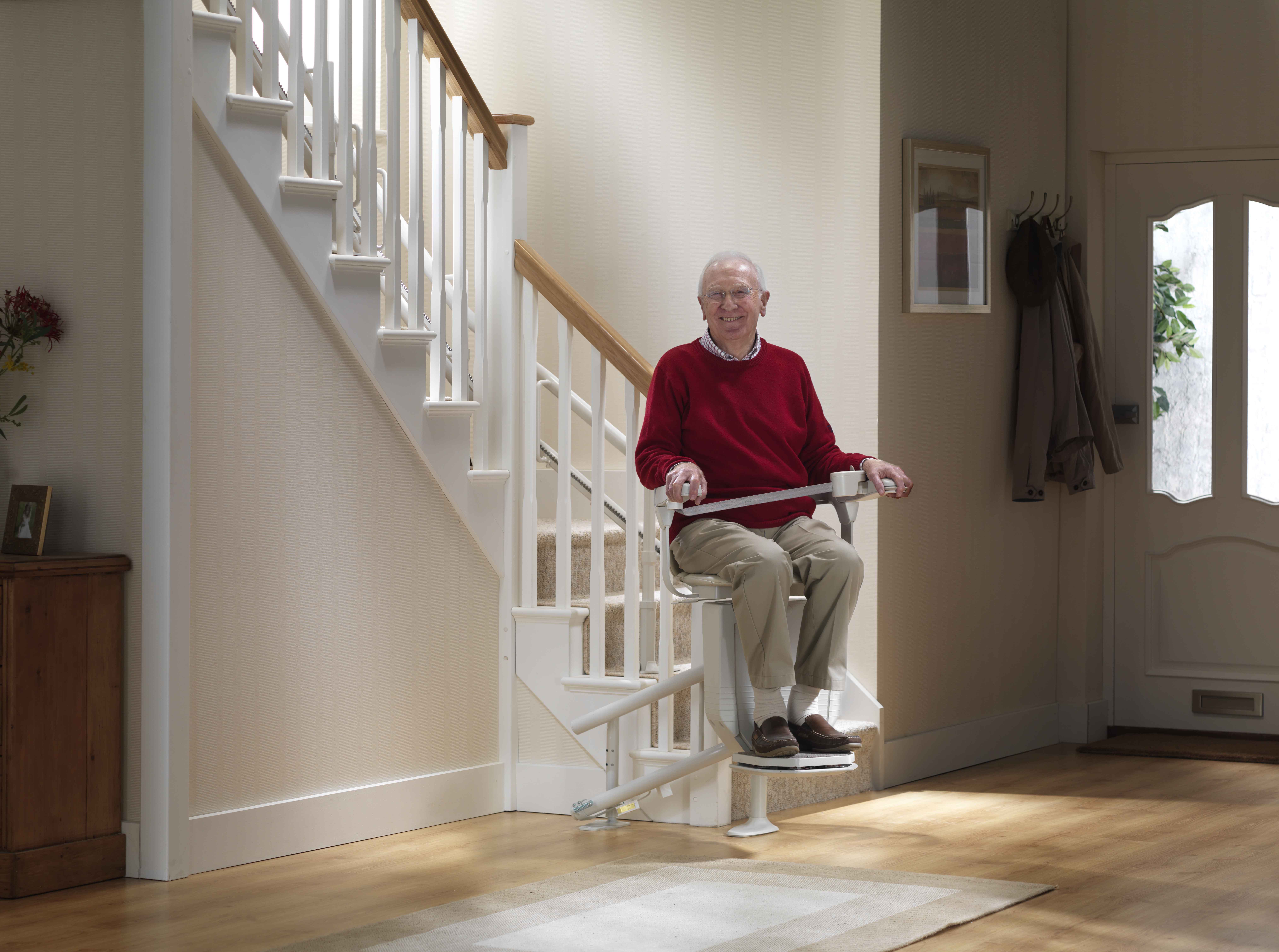 senior man sitting on a curved stairlift