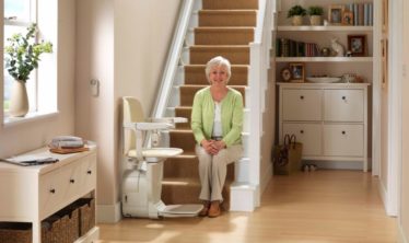 old lady on a staircase with a stairlift