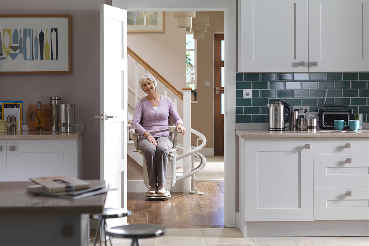 Woman on stairlift as alternative to homelifts